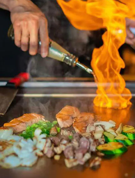 Teppanyaki cooking show with flames and grilled salmon at Kinzakaya Japanese Resturant, a Japanese restaurant in West Covina